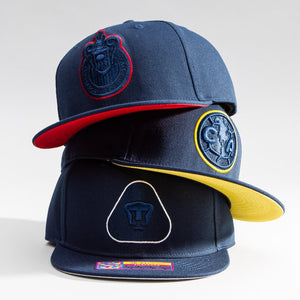 Three Fan Ink Eclipse Snapbacks stacked on top of each other. From top to bottom: Chivas, Club America, Pumas.