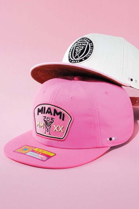 Inter Miami hats by Fan Ink on a pink backdrop