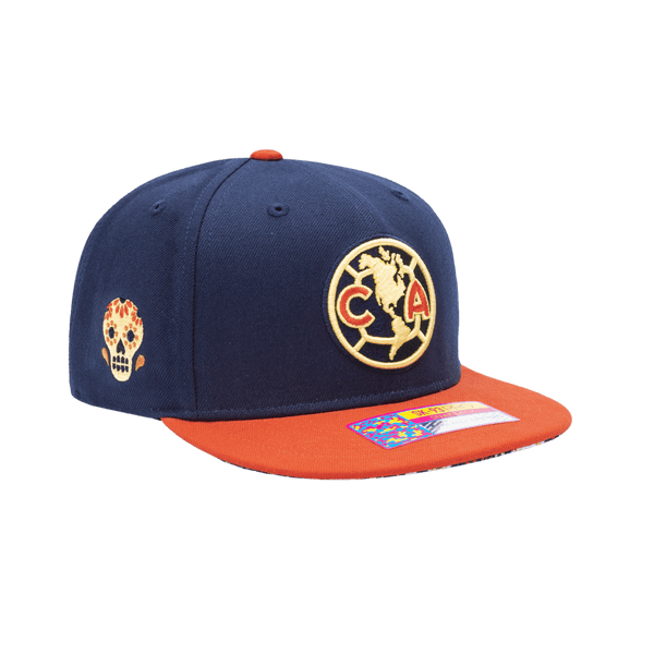 Club America Day of the Dead Snapback Hat with Club America logo embroidered on the front, floral skull embroidered on the side, "Dia de Muertos" embroidered on the back, and marigold and calavera print on the under peak. The hat has a high crown, flat peak brim, and a snapback closure.